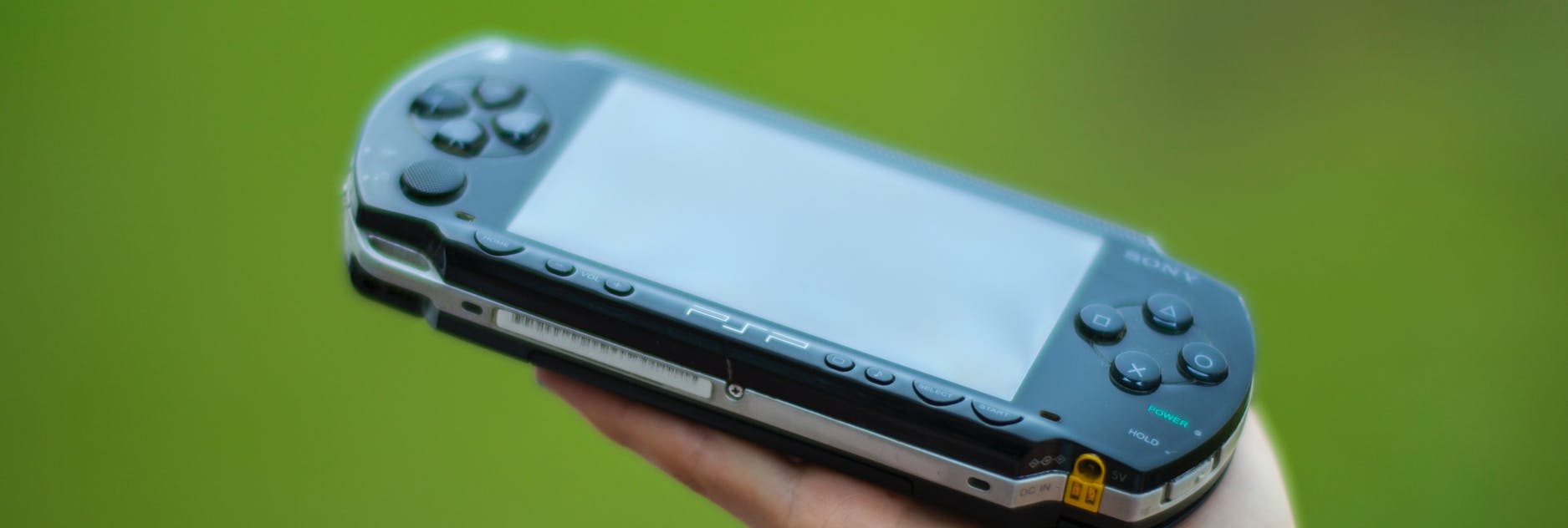 closeup photography of person holding black sony psp handheld console